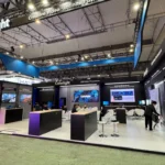 The Colorlight booth at ISE 2025 in Barcelona, showcasing state-of-the-art LED video processors and media server solutions. The booth features a sleek, modern design with vibrant lighting and multiple high-resolution screens demonstrating Colorlight's cutting-edge technology. Prominent signage displays the Colorlight logo and the slogan "Creative Video · Infinite Future," reflecting the brand's vision. The setup includes interactive areas for product demonstrations and tables for in-depth discussions with attendees. The booth's lively atmosphere and professional layout underline Colorlight's position as a leader in innovative video processing solutions.