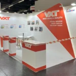 The VXT booth at Embedded World 2025 in Nuremberg, showcasing innovative solutions for industrial display, automotive, outdoor display, medical care, and ATM/kiosk applications. The booth is designed with a clean and professional look, featuring a prominent white and red color scheme and clear branding of VXT. Key technologies such as optical bonding, touch display, and IK10 PCAP touch are highlighted through visual demonstrations and informational panels. A welcoming seating area is available for visitors to discuss VXT's offerings, while a “STAFF ONLY” section indicates a private area for team members. The overall setup emphasizes VXT's dedication to cutting-edge advancements in display and touch technologies.